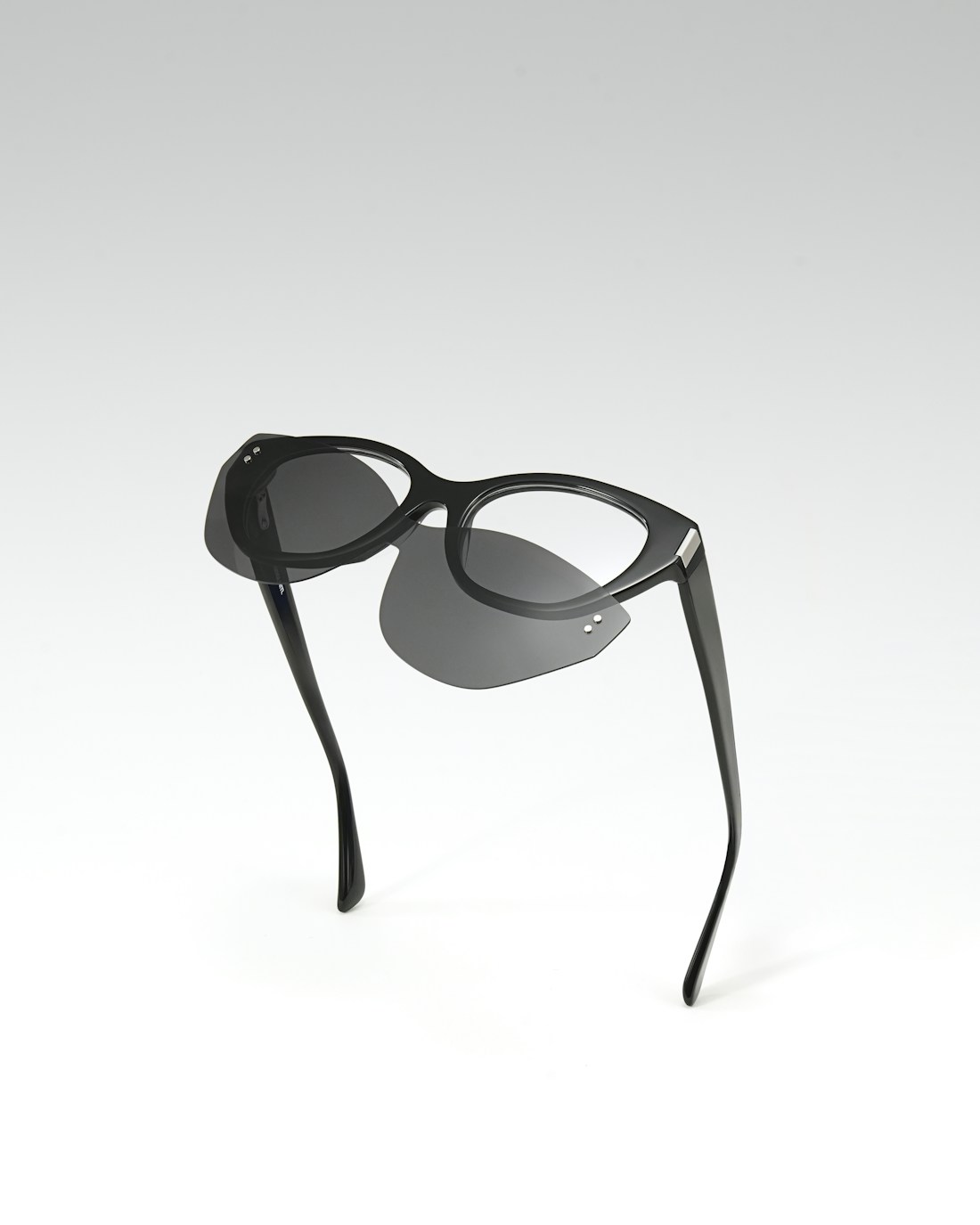 Black optical frames with flip-up sun lenses, illustrative eyewear photograph